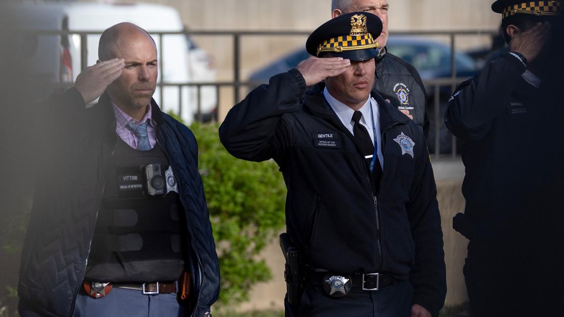 Members of the Chicago Police Department salute as the body of an officer is brought to the Cook County Medical Examiner’s office after he was fatally shot earlier in the day at Endeavor Health Swedish Hospital, April, 25, 2026. (Josh Boland/Chicago Tribune/TNS)