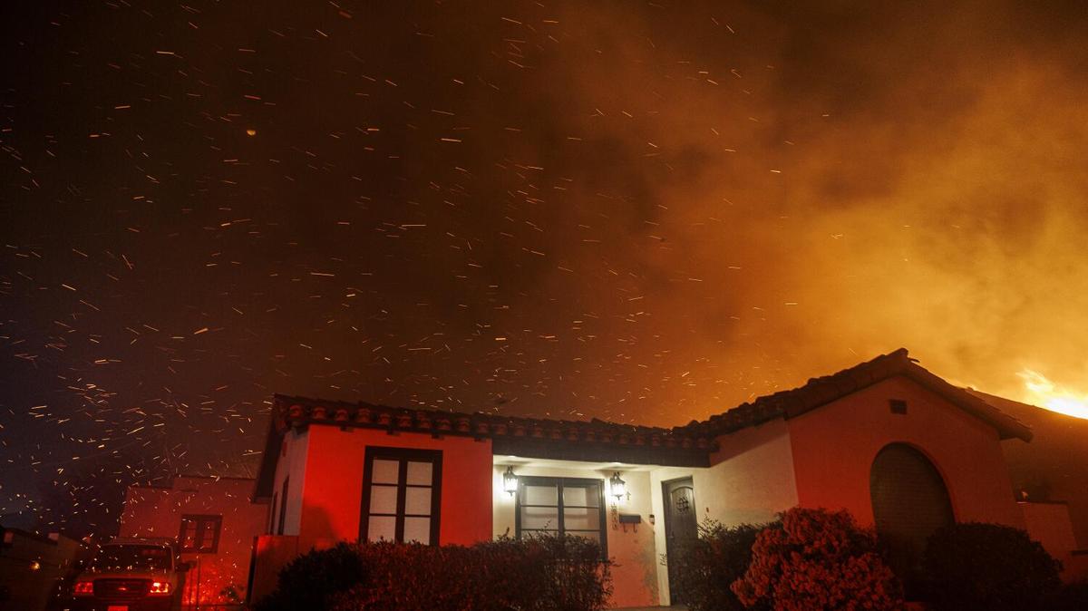 The wind whipped embers fly over a home on Vinedo Avenue during the Eaton fire on January 7, 2025 in Altadena, California. (Gina Ferazzi / Los Angeles Times)