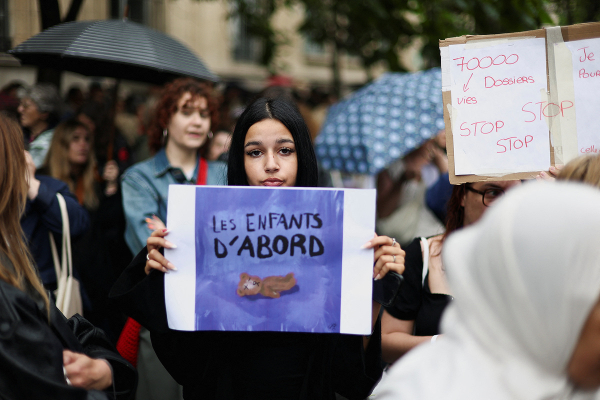 People attend a demonstration, amid nationwide calls to protest the handling by the criminal justice system of previous complaints involving child victims against the main suspect in the killing of 11-year-old Lyhanna, whose body was discovered near Fleurance after a days-long search, near the  Paris courthouse, France, June 8, 2026, in a protest supported by the #NousToutes movement. The sign reads: "Children first". REUTERS/Gonzalo Fuentes