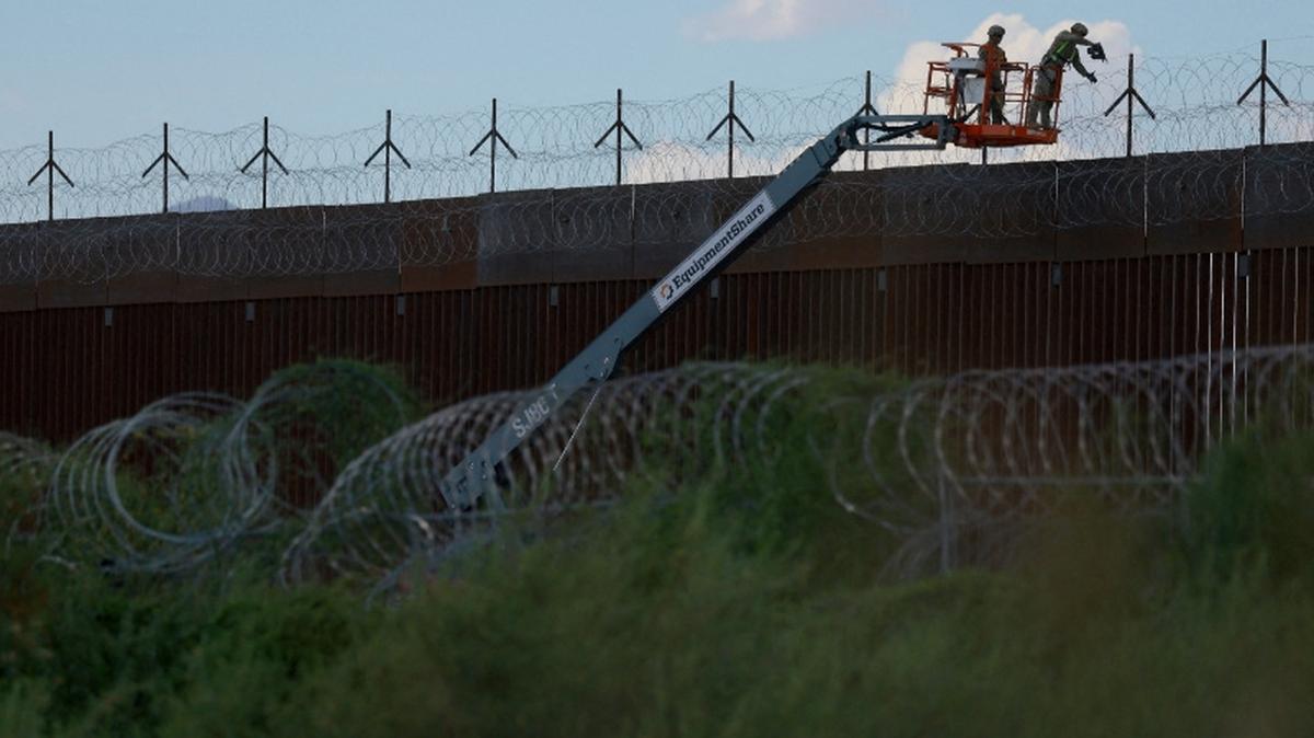 FILE PHOTO: U.S. Army combat engineers place razor wire on the U.S.-Mexico border wall to reinforce security in El Paso Texas, as seen from Ciudad Juarez, Mexico July 24, 2025. REUTERS/Jose Luis Gonzalez/File Photo