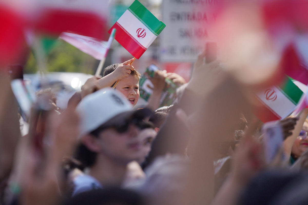 Soccer Football - FIFA World Cup 2026 - Iran leave Tijuana hotel ahead of first World Cup match - Tijuana, Mexico - June 14, 2026 Fans wave flags outside the hotel as the team leaves ahead of their first match REUTERS/Victor Medina