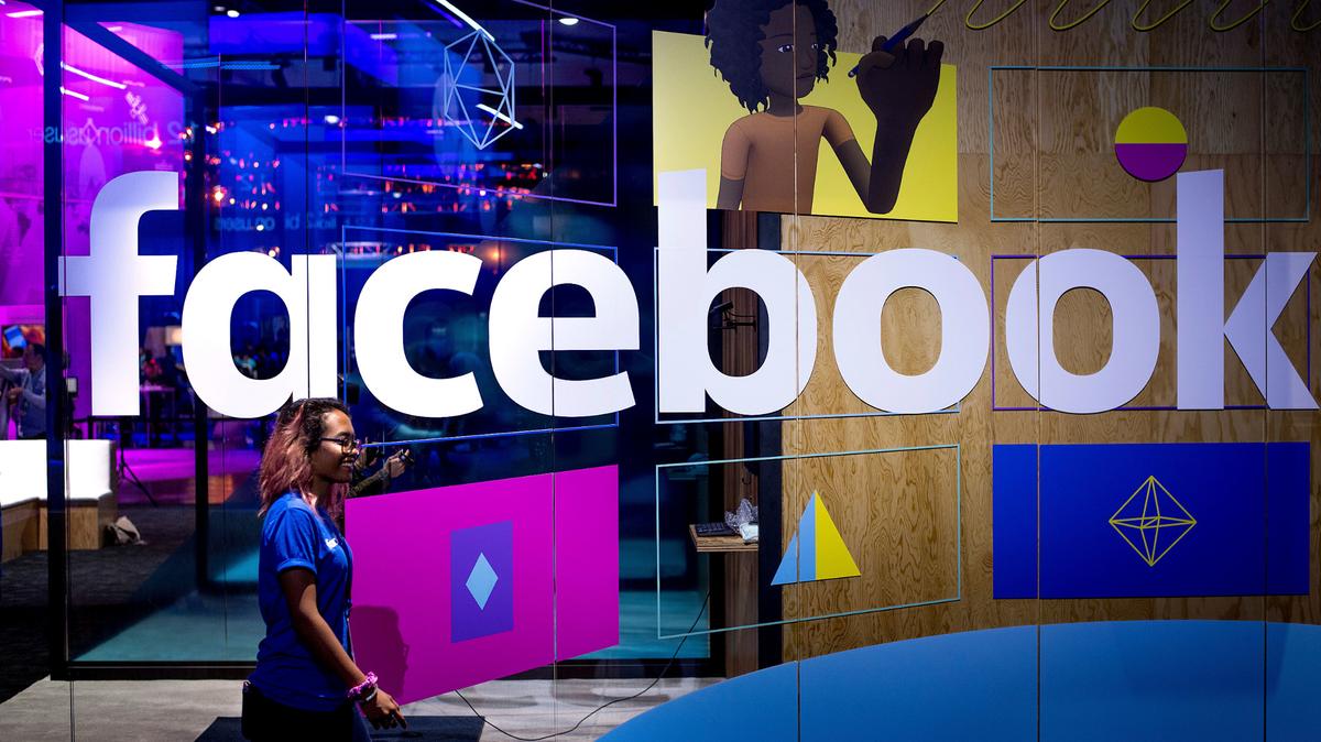 Una mujer pasa frente a un stand de Facebook en la conferencia de desarrolladores F8 de la empresa, en San José, California, el 18 de abril de 2017. (AP Foto/Noah Berger, File)