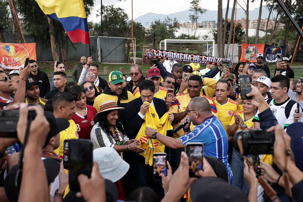Colombian presidential candidate Ivan Cepeda of the Historic Pact party, accompanied by his running mate Aida Quilcue, kisses the Colombian national football team's jersey during a campaign event with leaders of Colombian football fan groups, ahead of the presidential runoff election, in Bogota, Colombia, June 4, 2026. REUTERS/Jose Vargas