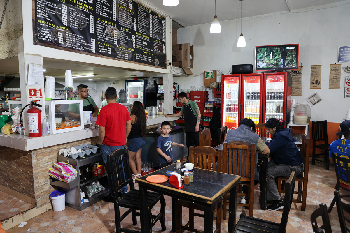Julio Mendoza, manager of the Las Delicias de la Obrera pozoleria restaurant, attends to a client, as many Mexicans say they feel excluded from the 2026 FIFA World Cup, despite the tournament's return to the country, citing high ticket prices, paid television access and strict commercial restrictions, while the restaurant cannot afford a special package to show the games, in Mexico City, Mexico, June 13, 2026. REUTERS/Diego Delgado