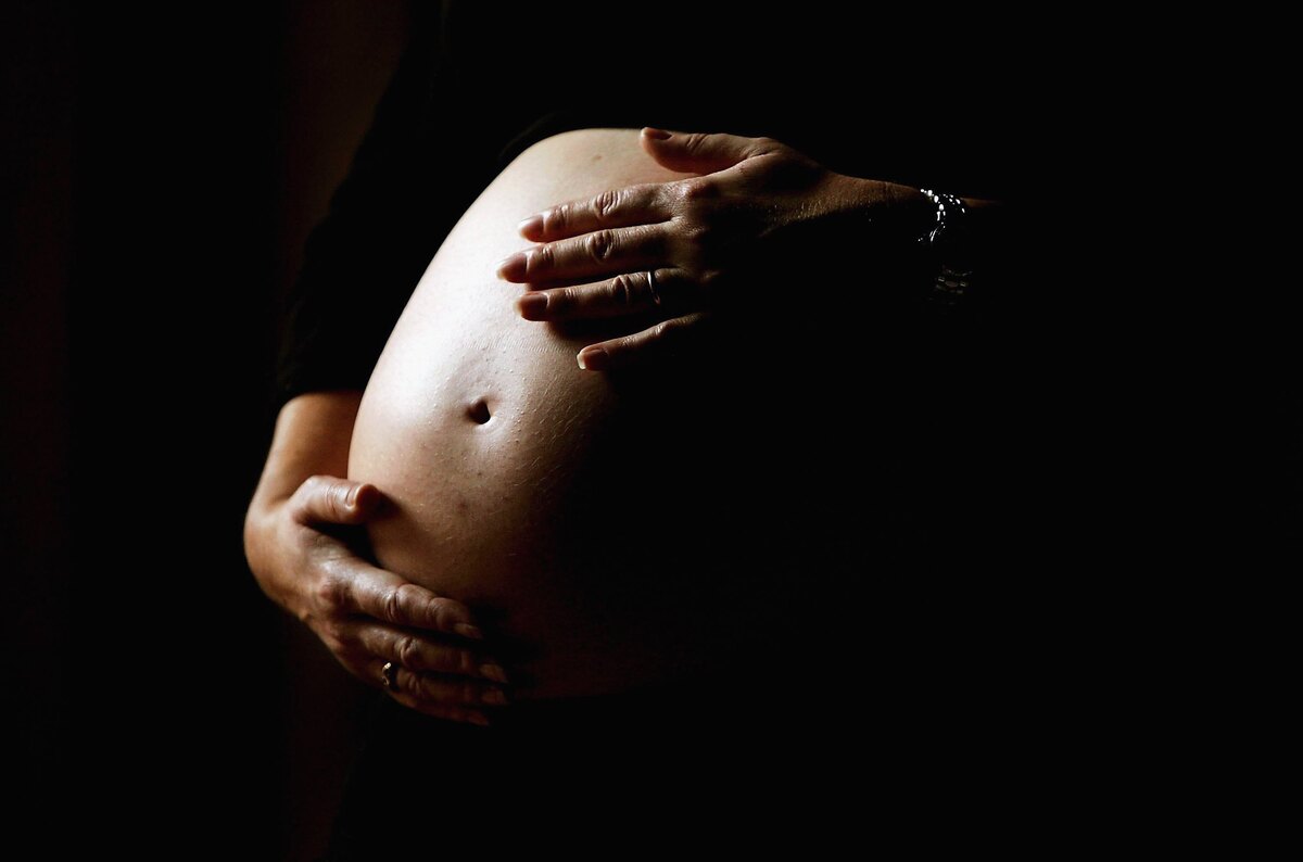  File: A pregnant woman holds her stomach on June 7, 2006, in Sydney, Australia. 