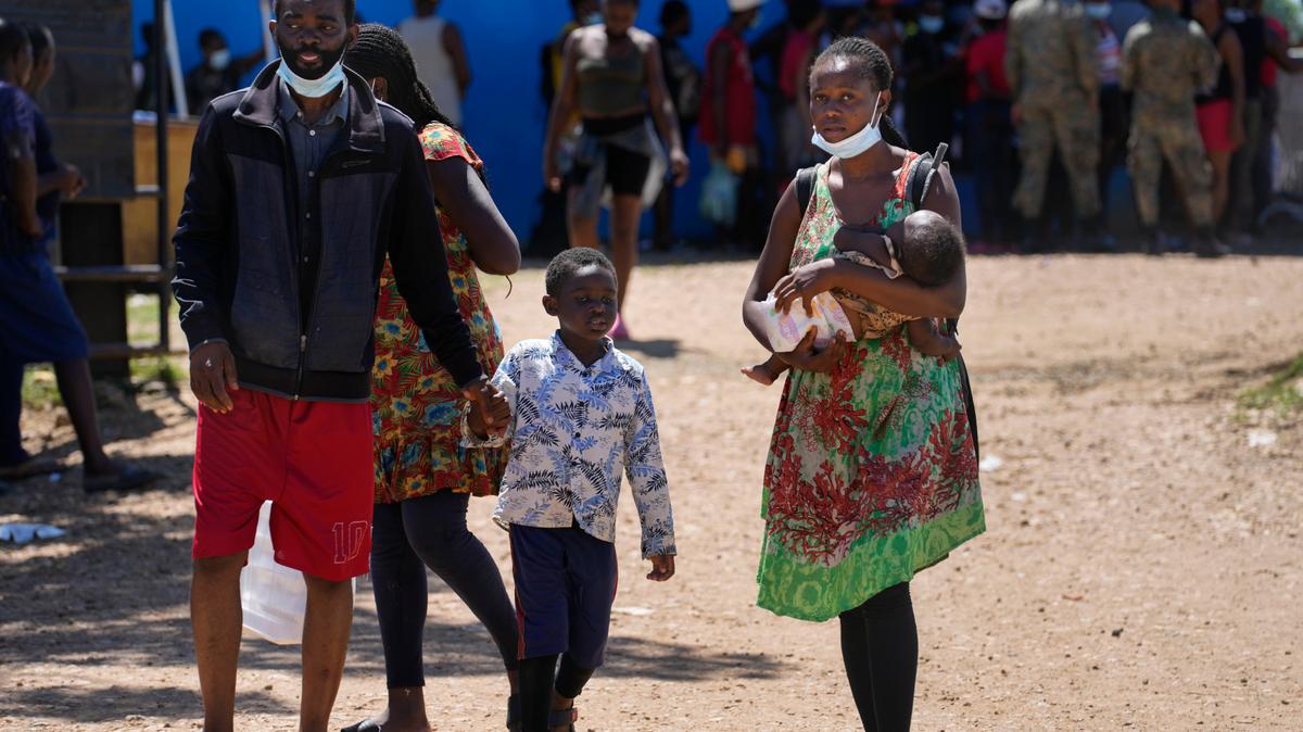 Migrantes, en su mayoría de Haití y con menores, caminan por los terrenos de una estación de recepción temporal en Lajas Blancas, provincia de Darién, Panamá, el viernes 1 de octubre de 2021. Entre enero y septiembre de 2021, la cifra de menores que arriesgaron su vida llegó a casi 19.000 --su máximo histórico-- según reveló el lunes 11 de octubre el Fondo de las Naciones Unidas para la Infancia (UNICEF). (Foto AP/Arnulfo Franco )
