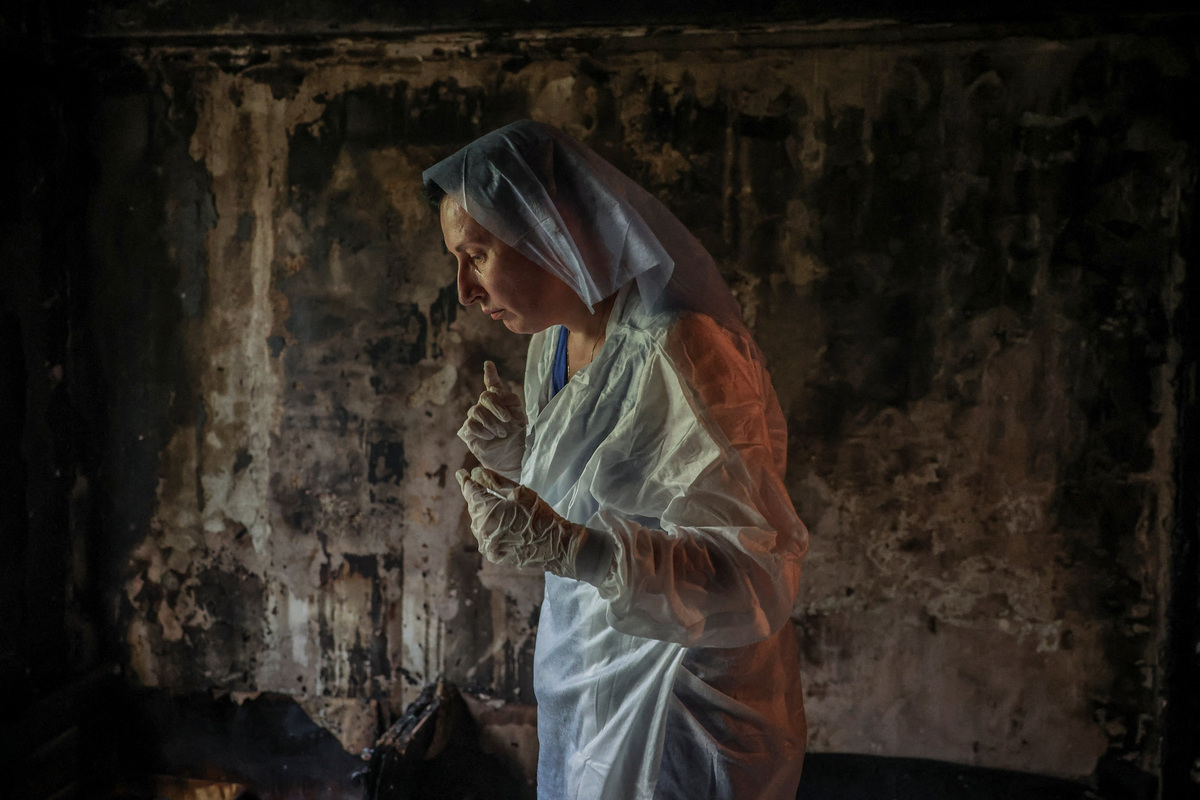 Iryna Plekhova, 42, resident who survived yesterday's Russian missile and drone attack, looks for her remaining personal belongings in the burned down apartment, which was damaged during the strike, amid Russia's attack on Ukraine, in Kyiv, Ukraine July 3, 2026. REUTERS/Alina Smutko