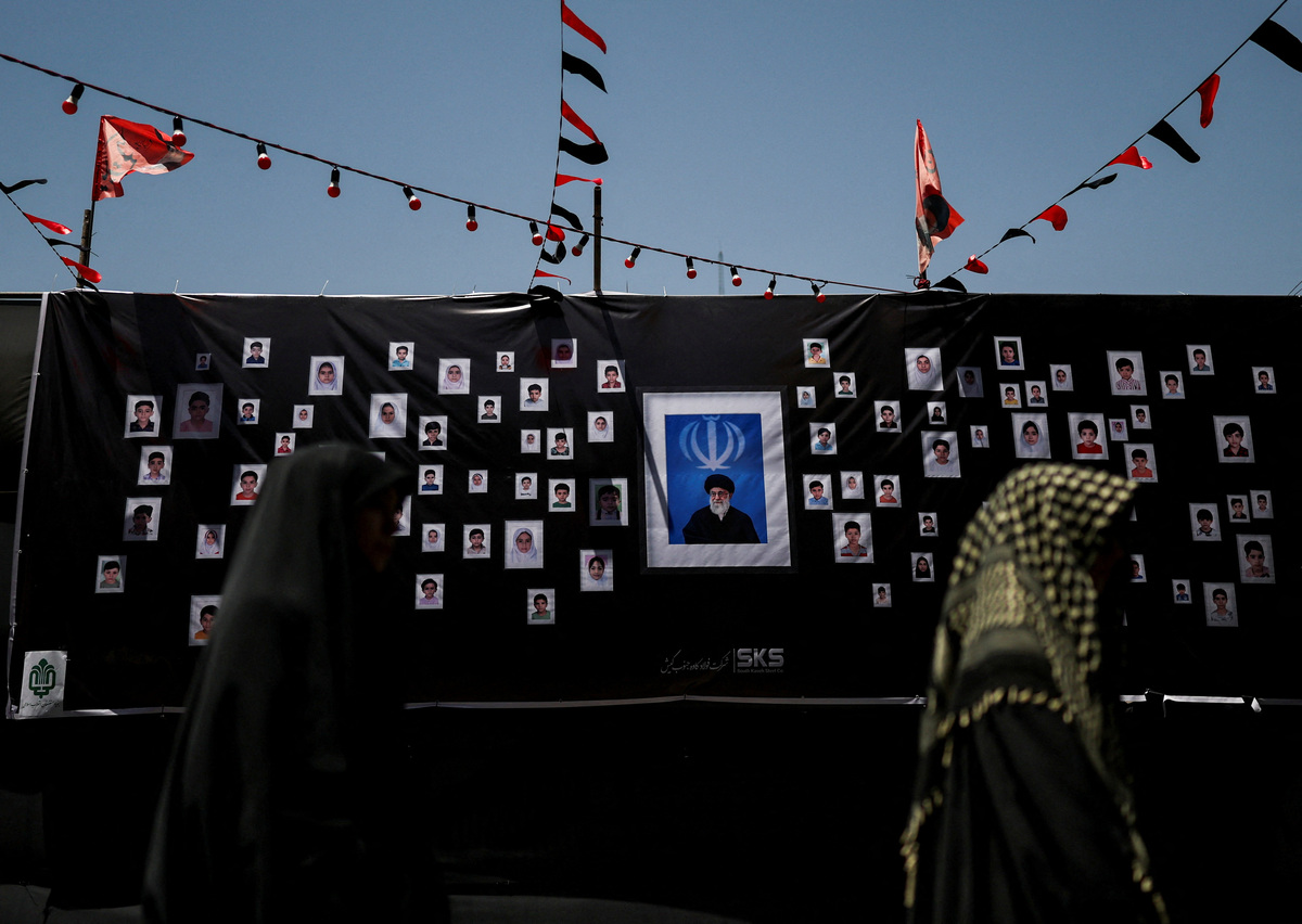 Women walk past a makeshift memorial for the schoolchildren who were killed in a strike on a girls' primary school in Minab in southern Iran on February 28, as people continue to pay their respects to the late Supreme Leader Ayatollah Ali Khamenei, in Tehran, Iran, July 5, 2026. REUTERS/Mohammed Salem   Foreign media in Iran operate under guidelines set by the Ministry of Culture and Islamic Guidance, which regulates press activity and permissions  