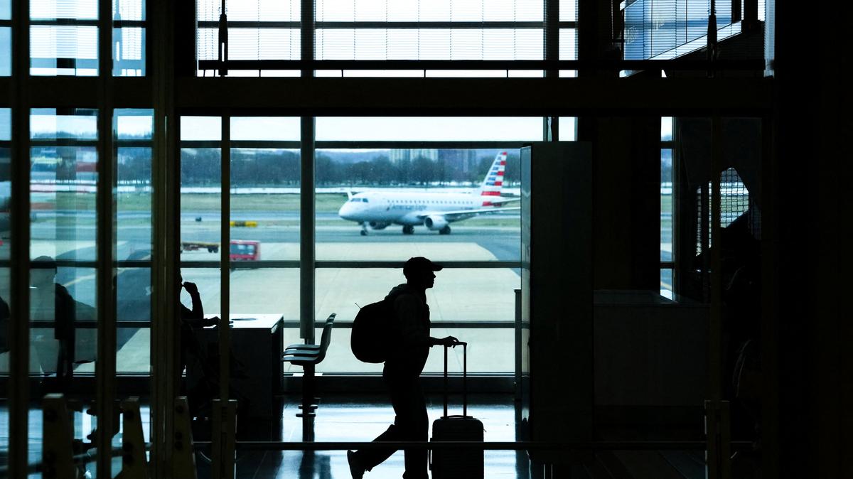 A passenger walks through Ronald Reagan International Airport in Arlington, Virginia., U.S., March 15, 2026. REUTERS/Aaron Schwartz