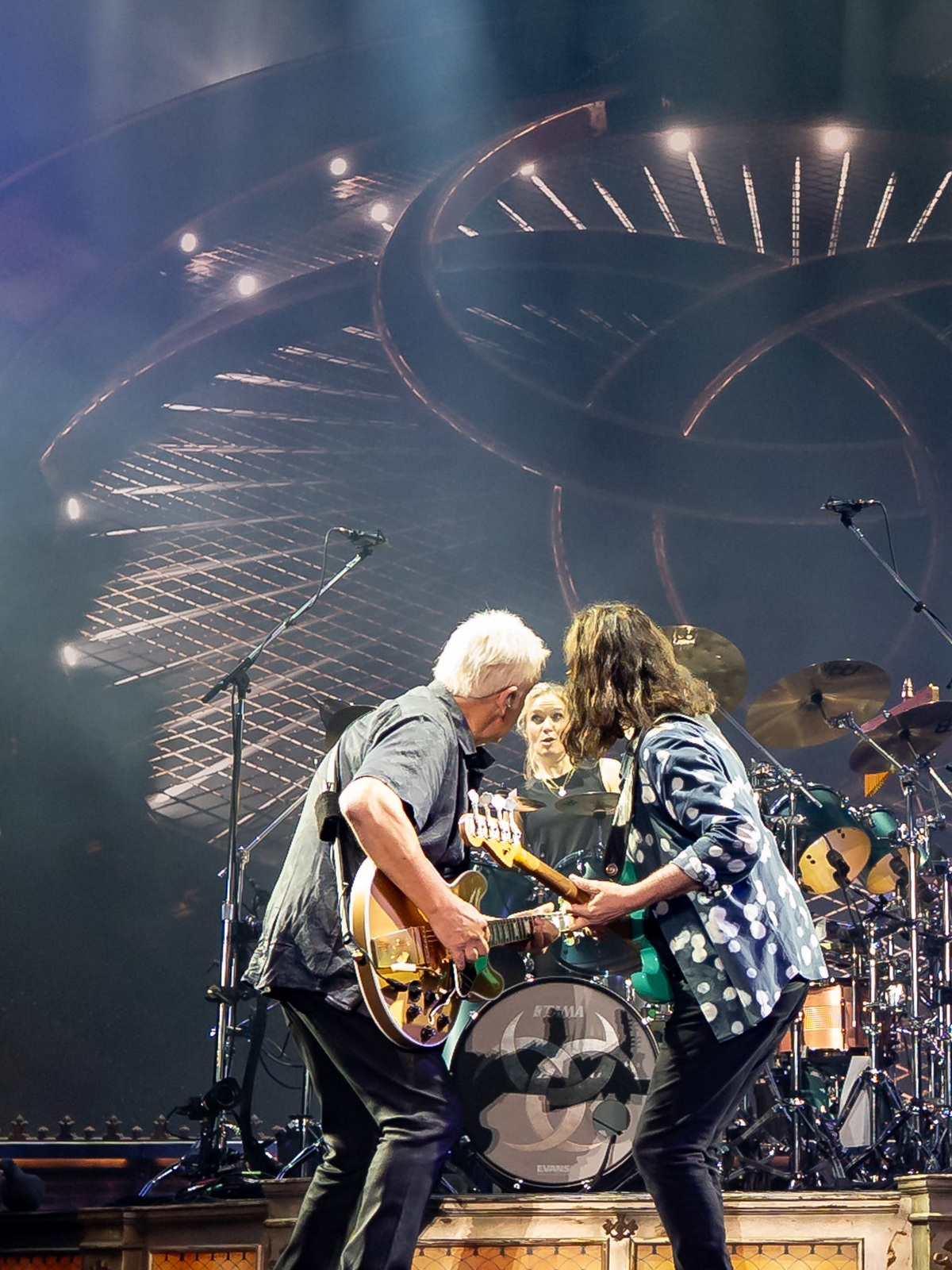 Rush guitarist Alex Lifeson (left), new drummer Anika Nilles and bassist/singer Geddy Lee share a moment during the band's June 7, 2026 return at the Kia Forum in Los Angeles.