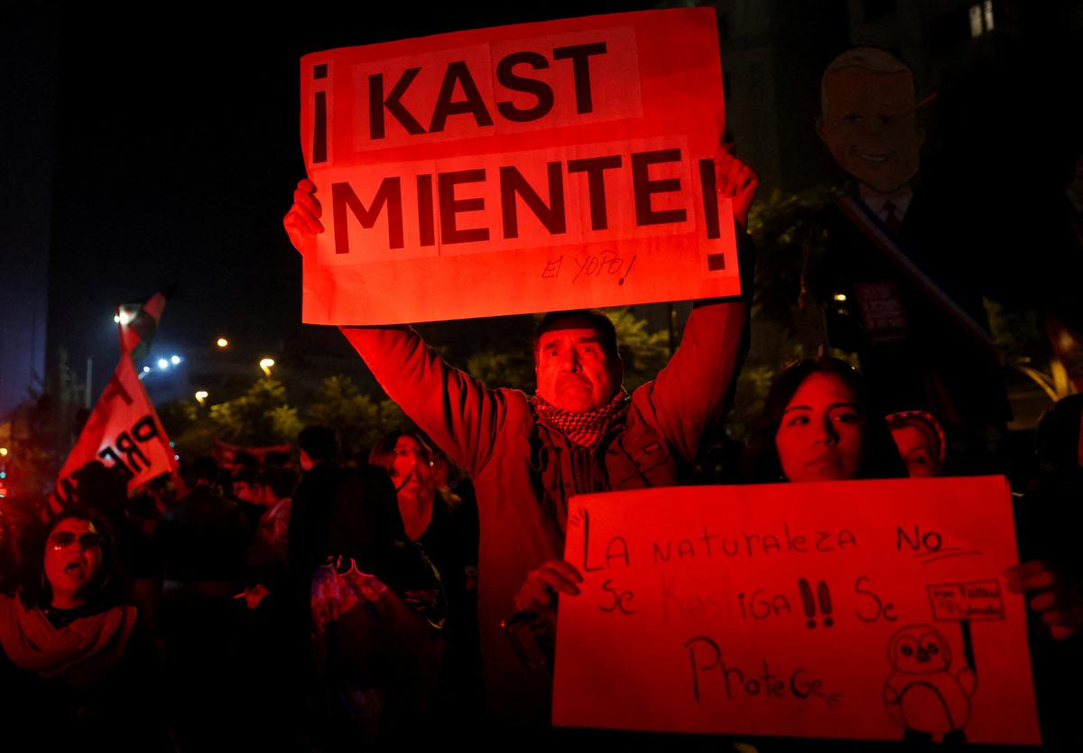 Demonstrators hold posters that read "Kast lies" and "Nature is not punished (with the word modified in a play on Kast's name)!! It is protected" during a protest against the policies of Chile's President Jose Antonio Kast, in Santiago, Chile, June 1, 2026. REUTERS/Pablo Sanhueza