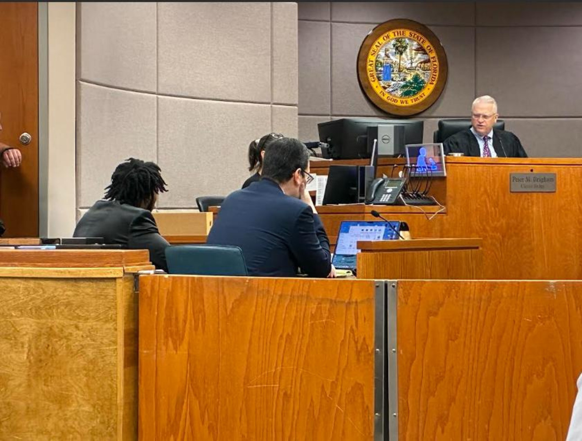 Circuit Judge Peter Brigham talks with Dexavion J'Neil Brown, seated at left at the defense table, during Brown's trial on July 9, 2026.