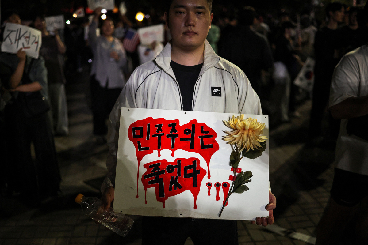 A demonstrator holds a sign reading, "Democracy died", as people surround a vote-counting centre to protest a controversy over a shortage of ballot papers that disrupted voting in the local election and to call for a rerun of the election, in Seoul, South Korea, June 6, 2026. REUTERS/Kim Hong-Ji