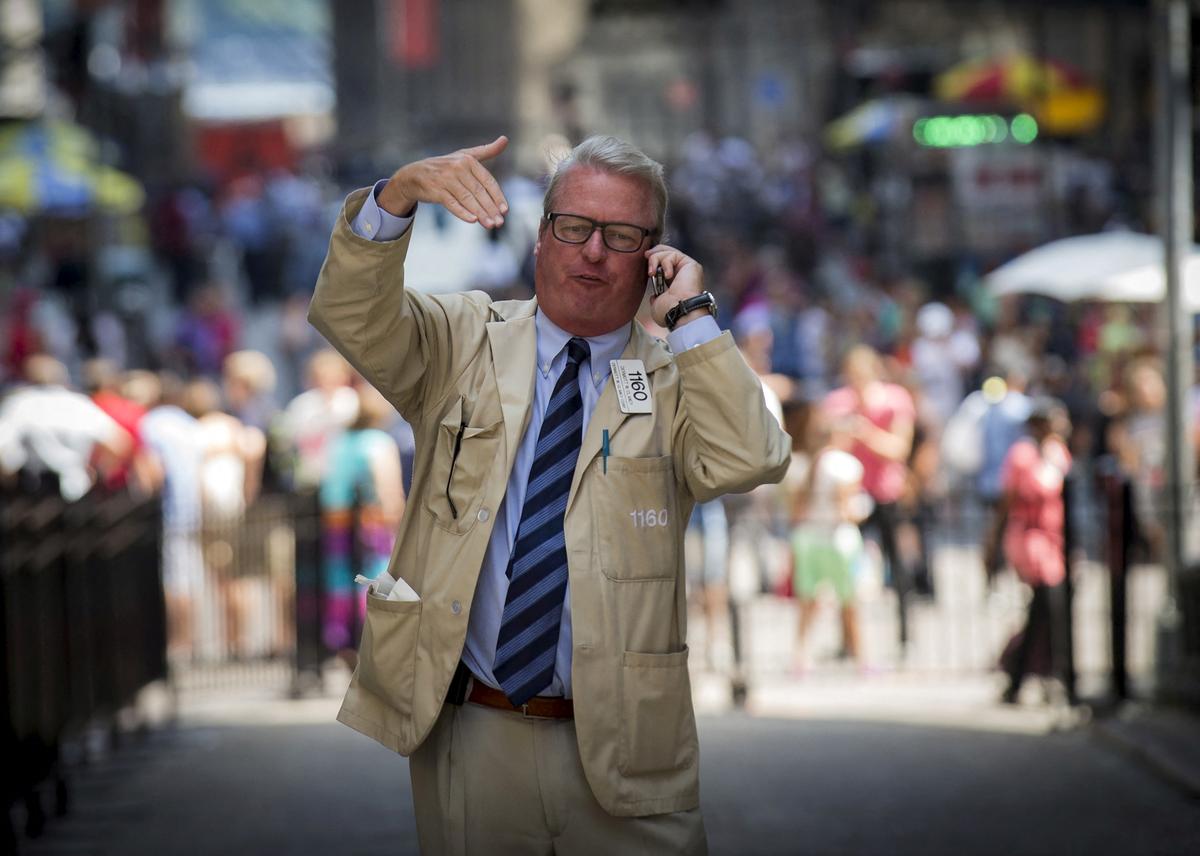 FILE PHOTO: A trader talks on his phone outside the New York Stock Exchange on Wall St. August 24, 2015. REUTERS/Brendan McDermid/File Photo