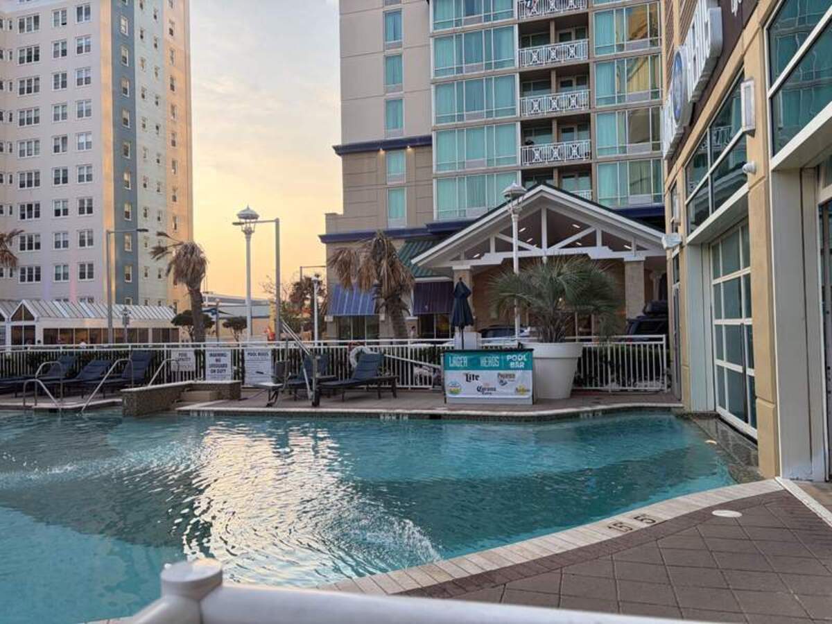  Watching the sky change colors over the outdoor pool at the  Hilton  Garden Inn makes winding down after a beach day completely effortless. It’s the perfect spot for families who want prime beachfront access without a luxury price tag. Photo credit: Emily Caldwell 