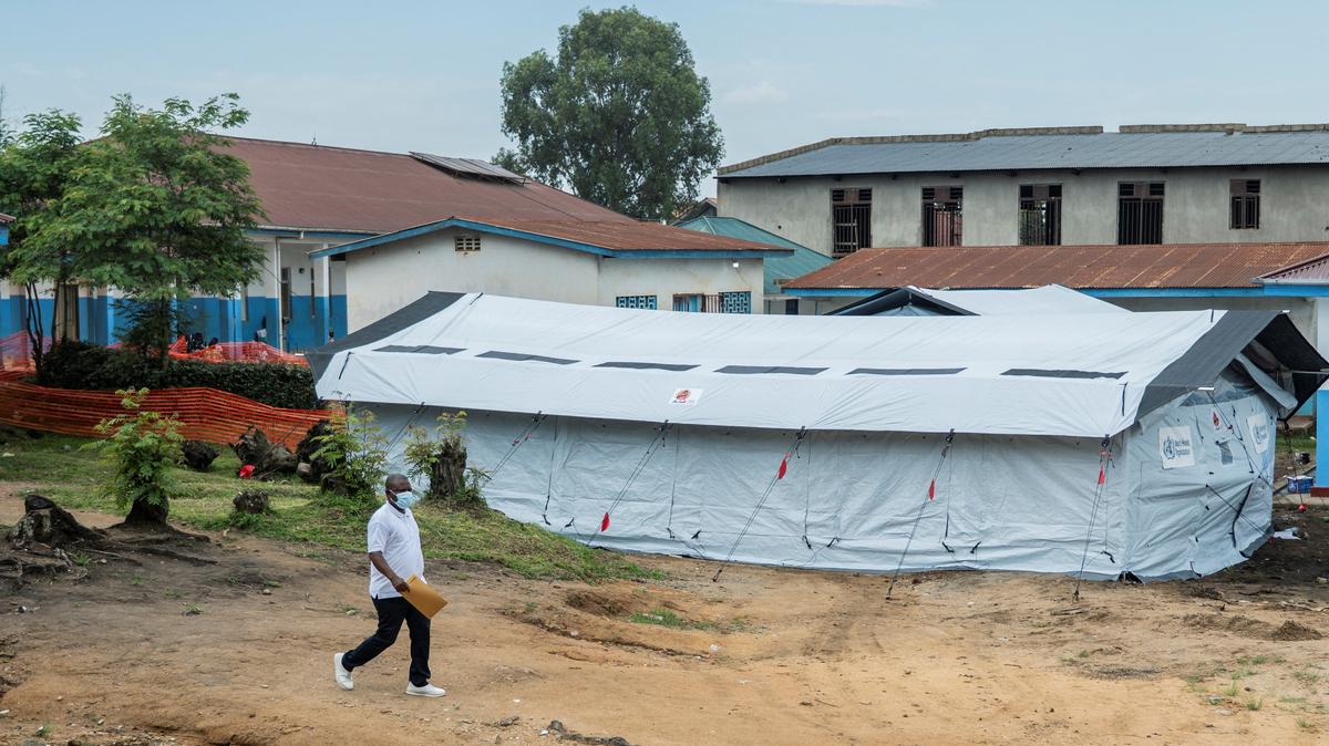 A man walks past the treatment center set up by the NGO Alima in the courtyard of Bunia General Referral Hospital following a resurgence of Ebola involving the Bundibugyo strain, a rarer variant of the virus with no approved vaccine currently available, in Bunia, Ituri province of the Democratic Republic of Congo May 21, 2026. REUTERS/Stringer
