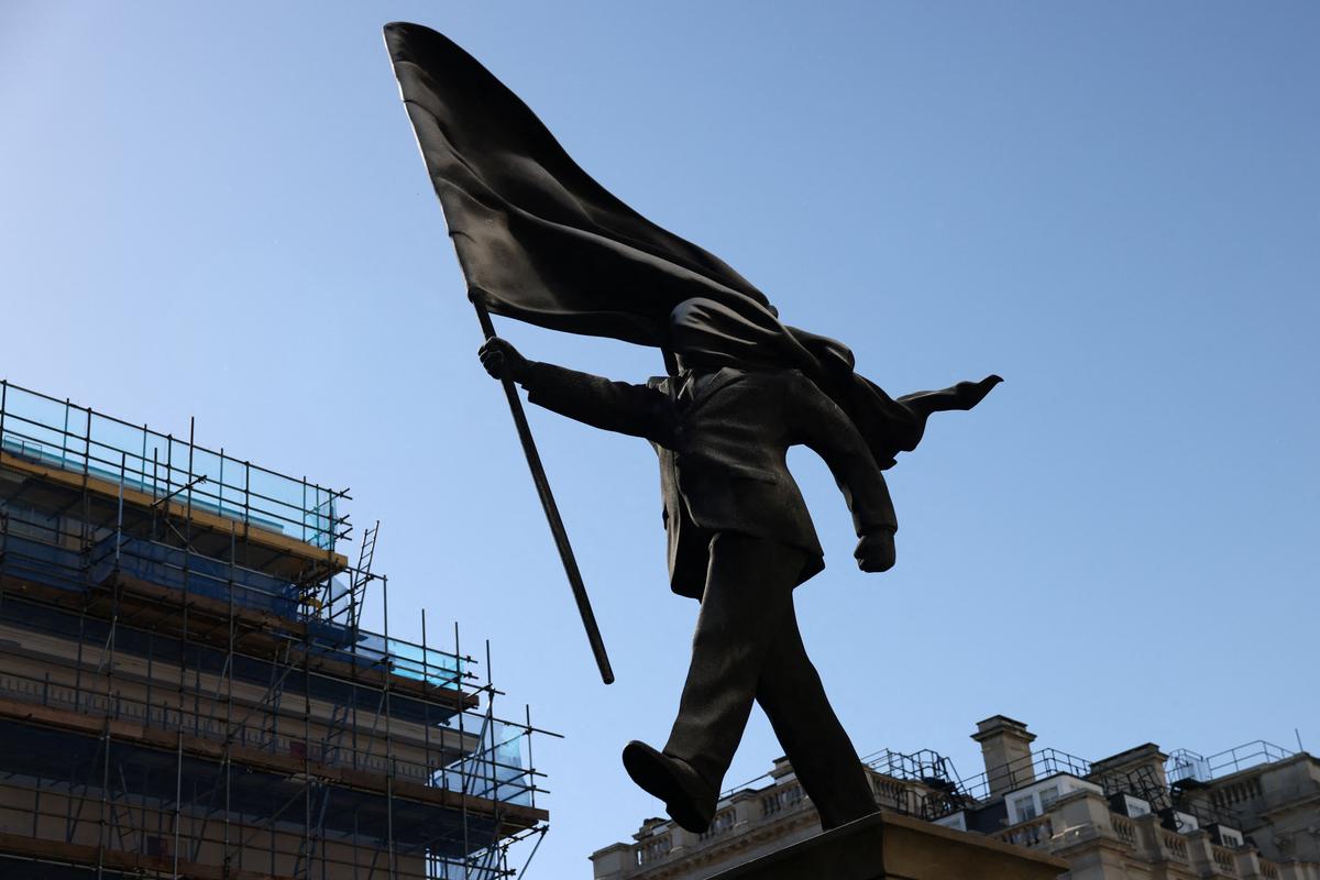 A statue depicting a person stepping off the plinth while carrying a flag covering their face, by British street artist Banksy, stands in London, Britain, April 30, 2026. REUTERS/Jack Taylor