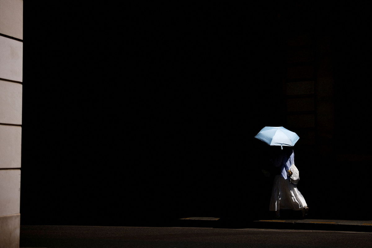 FILE PHOTO: A person takes shelter under an umbrella as temperatures rise in Paris, during a heatwave affecting a majority of the country, France, July 10, 2026. REUTER/Sarah Meyssonnier/File Photo