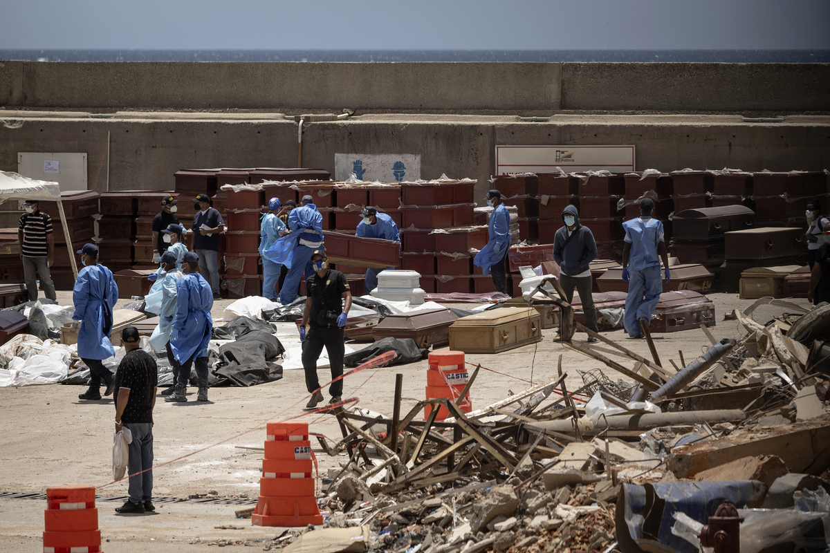 Workers with coffins at an improvised morgue at the port in La Guaira, Venezuela, June 29, 2026. As the death toll mounts, thousands of bodies have overwhelmed Venezuela's forensic system, turning a seaport into a temporary morgue. (Fabiola Ferrero/The New York Times)