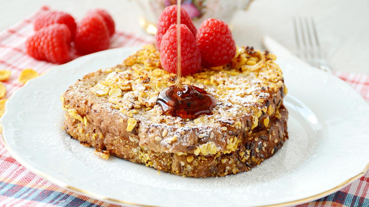 Breakfast image: chocolate stuffed french toast with cornflakes crust poured with maple syrup and topped with fresh raspberries