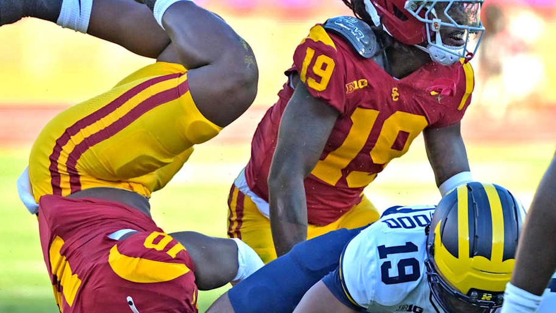  Oct 11, 2025; Los Angeles, California, USA; Michigan Wolverines quarterback Bryce Underwood (19) is stopped by USC Trojans defensive end Braylan Shelby (10) and safety Bishop Fitzgerald (19) after he ran the ball in the first half at United Airlines Field at the Los Angeles Memorial Coliseum. Mandatory Credit: Jayne Kamin-Oncea-Imagn Images | Jayne Kamin-Oncea-Imagn Images 