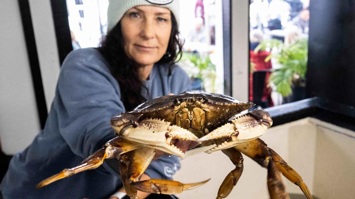 Shala Mansur-OKeefe, owner of Jons Fish Market, holds a Dungeness crab at the market and restaurant at the harbor in Dana Point, CA on Friday, December 30, 2022. (Photo by Paul Bersebach, Orange County Register/SCNG)