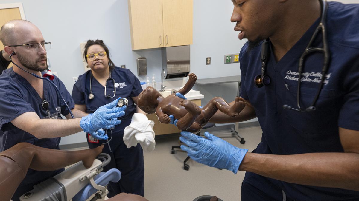 Community College of Philadelphia nursing students Ridge M. Bair (left), Edna Perrusquia (center) and Aahmid Mink take part in a newborn delivery exercise in the school's new simulation lab. The lab uses realistic mannequins to replicate medical scenarios ranging from emergencies to childbirth. 