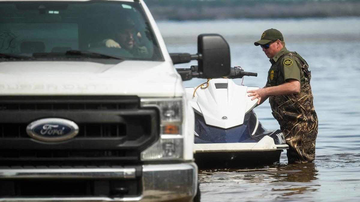 A U.S. border patrol agent loads a personal watercraft back onto a hitch hauler after taking it out on Black Lake while helping other law enforcement agencies looking for homeowners who may need help evacuating on April 17, 2026, in Cheboygan, Michigan. (Katy Kildee/The Detroit News/TNS)