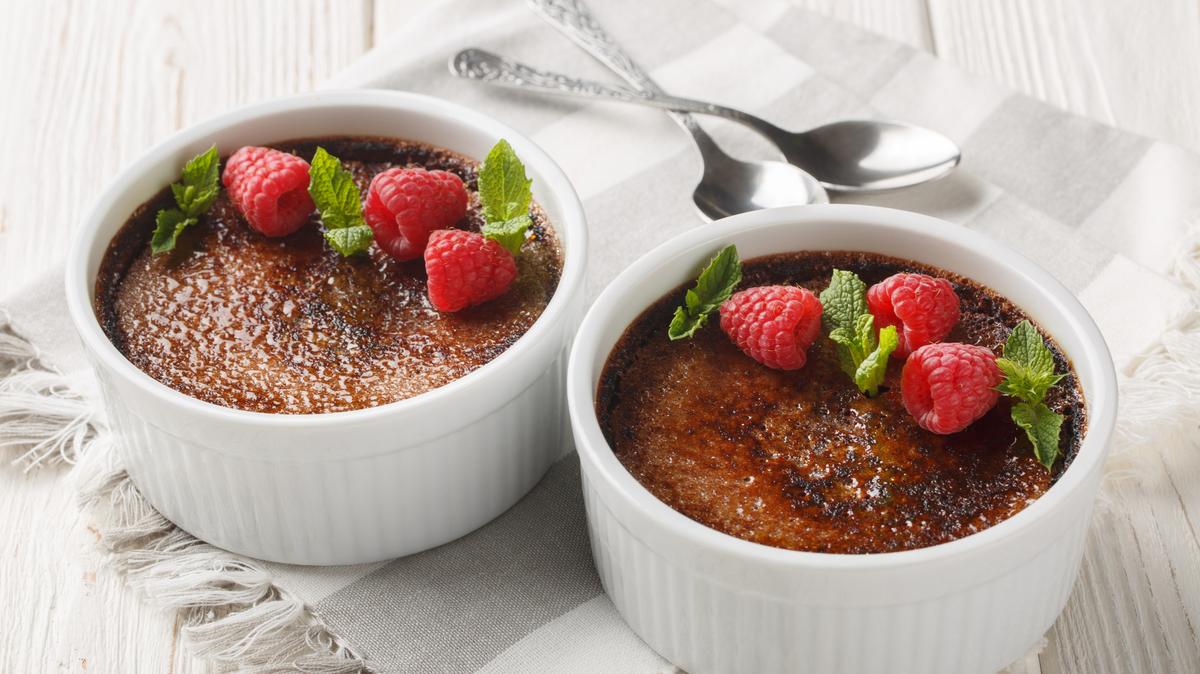 Chocolate creme brulee dessert consisting of a rich custard base topped with a layer of hardened caramelized sugar close-up in a ramekin on the table. Horizontal