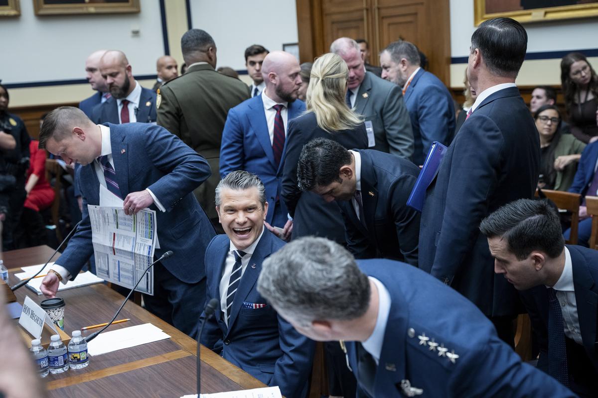 Defense Secretary Pete Hegseth laughs as he chats with Gen. Dan Caine, chairman of the Joint Chiefs of Staff, during a pause in a House Armed Services Committee hearing on the Department of Defense's budget request on Capitol Hill in Washington, on Wednesday, April 29, 2026. (Haiyun Jiang/The New York Times)