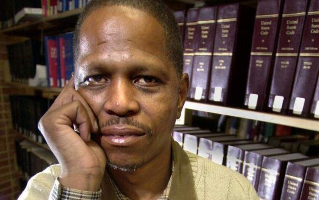 Alvin Sykes in 2004 with a photo of Emmett Till and his mother, Mamie Till-Mobley.