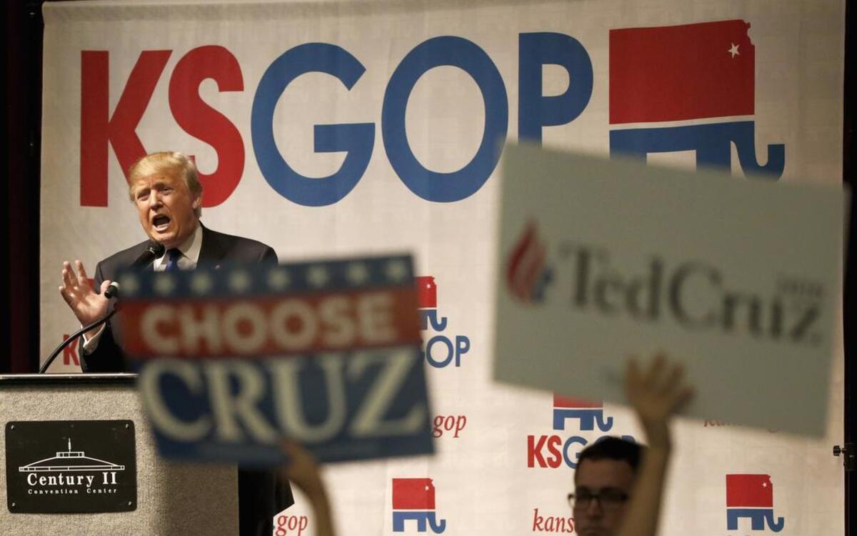 Donald Trump spoke last Saturday in Wichita as a Ted Cruz supporter held up signs.