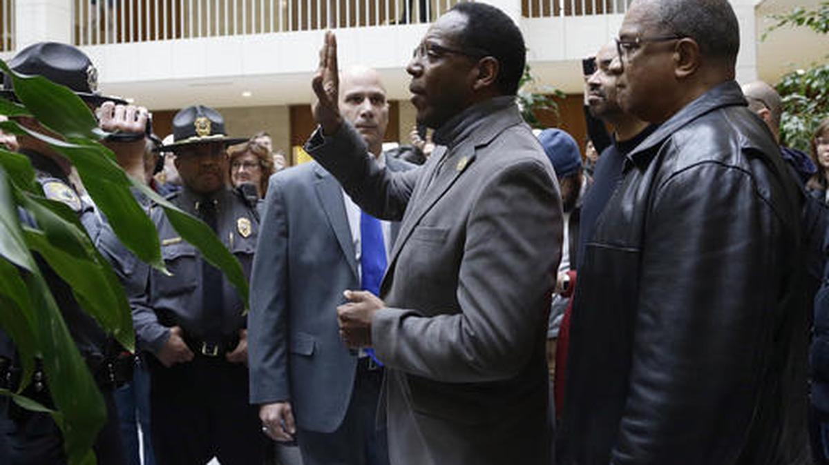 Rev. Curtis Gatewood, with the North Carolina chapter of the NAACP raises a hand as he is confronted by General Assembly police at a demonstration during a special session of the North Carolina Legislature in Raleigh in 2016.